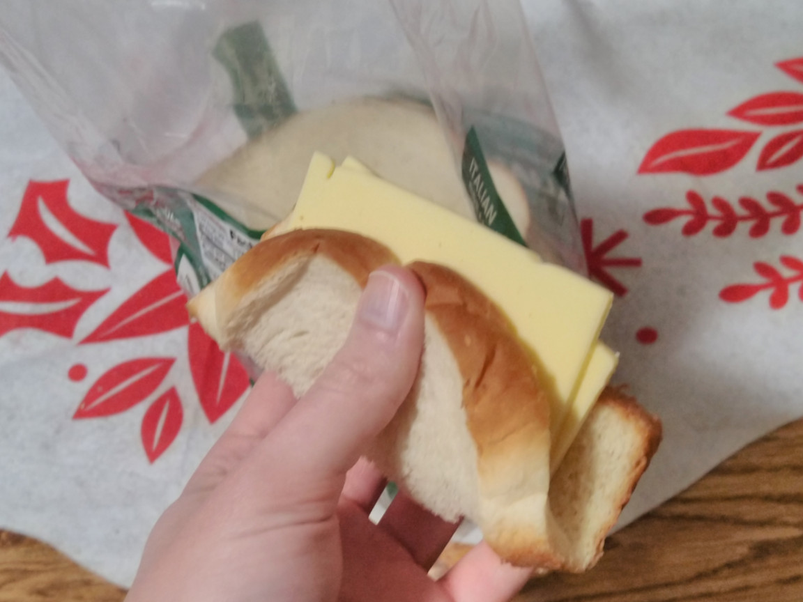 A left hand holding a sandwich